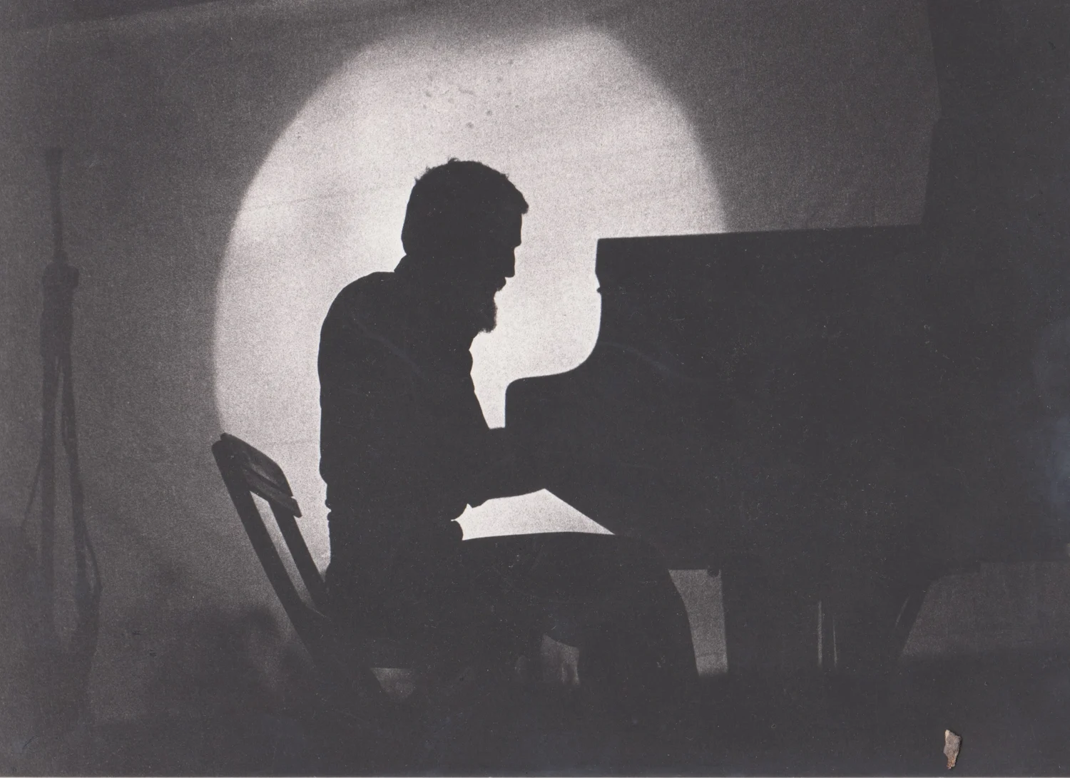 Silhouette di Raul Lovisoni al pianoforte nel cono di luce, Teatro Tenda di Milano, 1978